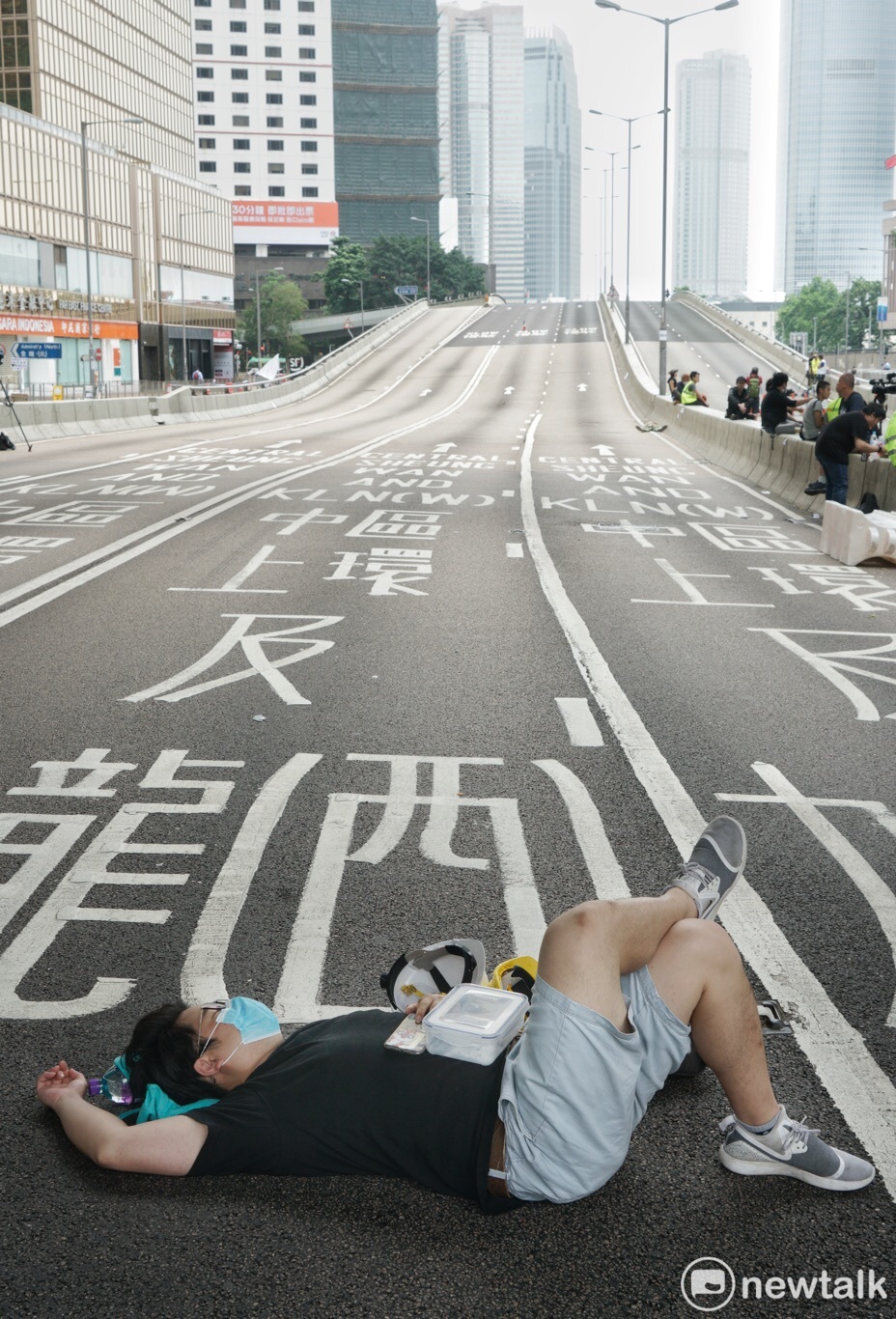 一位香港青年在政府總部前躺下,在已經封閉的夏慤道上休息。 圖:張良一/攝 一位香港青年在政府總部前躺下,在已經封閉的夏慤道上休息。 圖:張良一/攝