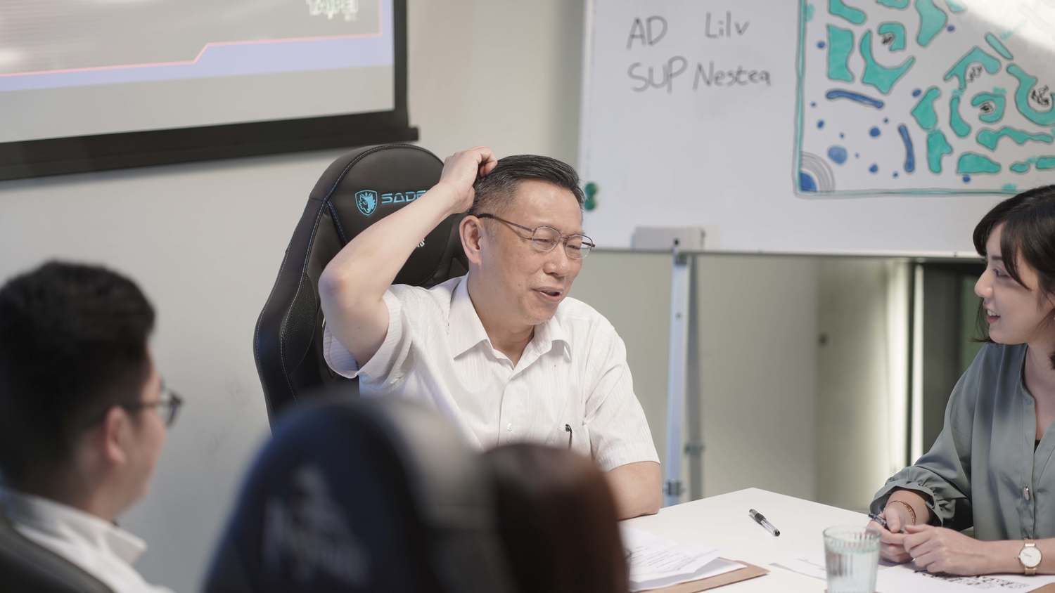 柯文哲在劇情配合情境中再度施展招牌的「搔頭」。 圖:杰藝文創/提供 柯文哲在劇情配合情境中再度施展招牌的「搔頭」。 圖:杰藝文創/提供