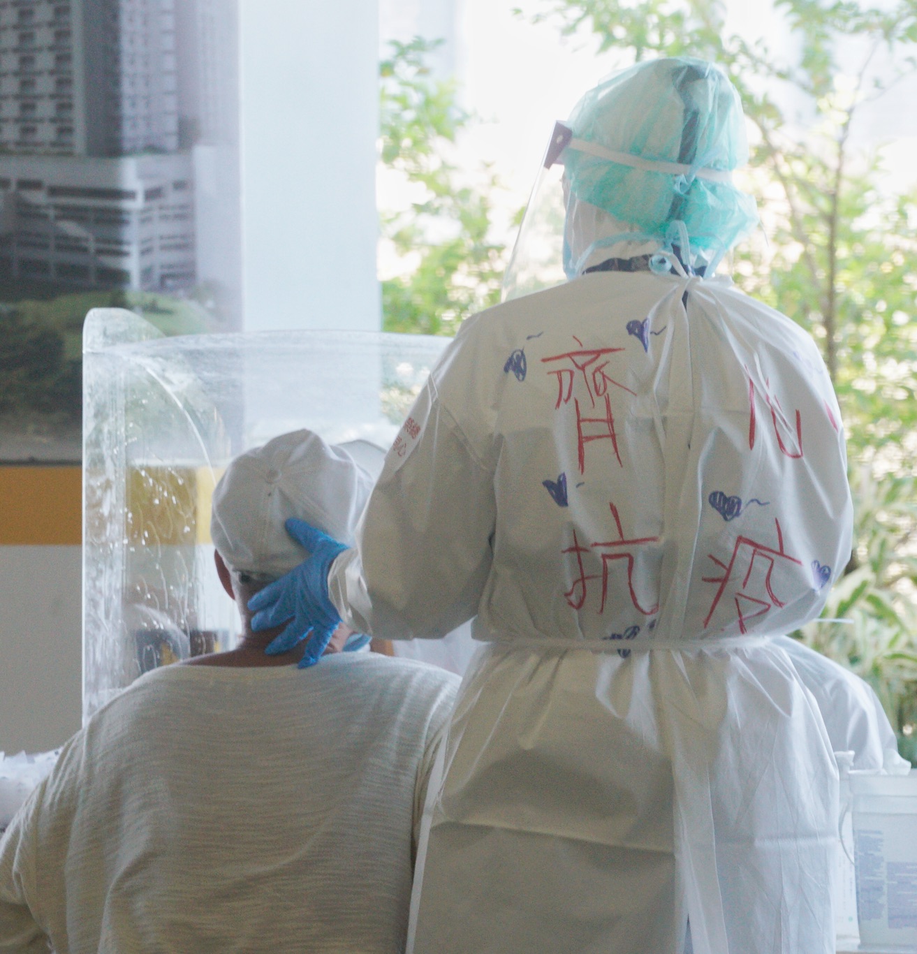 台北市府上午針對環南市台北市府上午針對環南市場有出現過確診者的漁產區、獸肉區!自治會以及附近里民,再進行一次大規模PCR篩檢,預計將篩檢近4千人。圖為一位榮總醫護人員在防護衣上寫上「齊心抗疫」。 圖:張良一/攝 台北市府上午針對環南市台北市府上午針對環南市場有出現過確診者的漁產區、獸肉區!自治會以及附近里民,再進行一次大規模PCR篩檢,預計將篩檢近4千人。圖為一位榮總醫護人員在防護衣上寫上「齊心抗疫」。 圖:張良一/攝