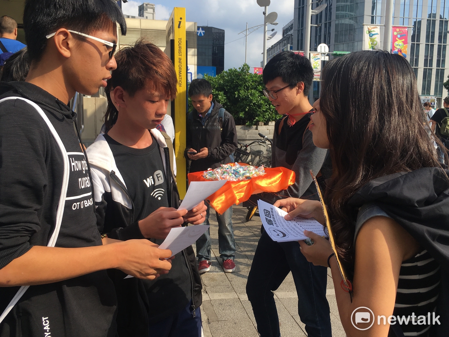 學生們沿路發放糖果給路人,介紹七天假與一例一休。 圖:黃韋銓/攝 學生們沿路發放糖果給路人,介紹七天假與一例一休。 圖:黃韋銓/攝