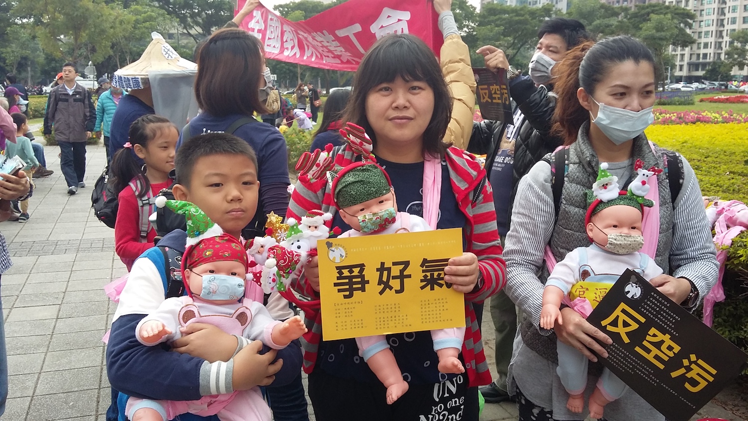 高雄市公共托嬰中心也組隊反共污,揹起洋娃娃上陣。 圖:金名攝 高雄市公共托嬰中心也組隊反共污,揹起洋娃娃上陣。 圖:金名攝