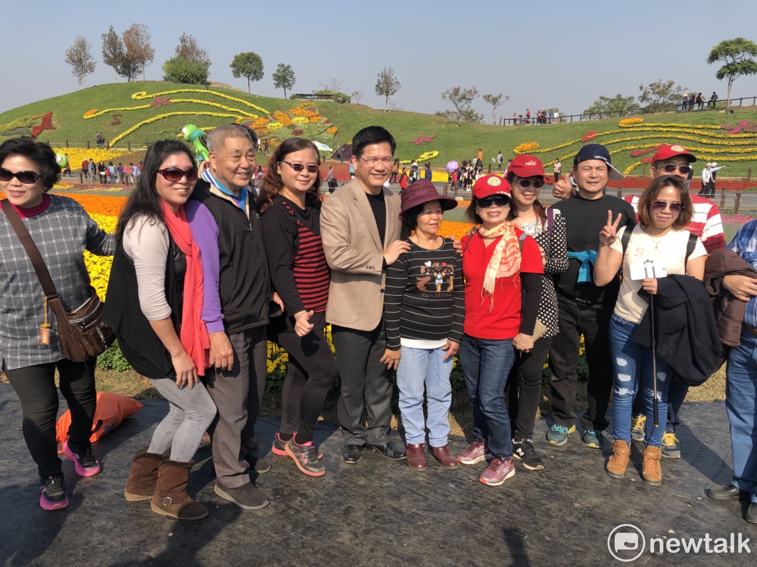 參加花毯節的遊客紛紛搶著與台中市長林佳龍合照,,讓他幾乎成了會場的人形立牌。 圖:王鵬宇/攝 參加花毯節的遊客紛紛搶著與台中市長林佳龍合照,,讓他幾乎成了會場的人形立牌。 圖:王鵬宇/攝