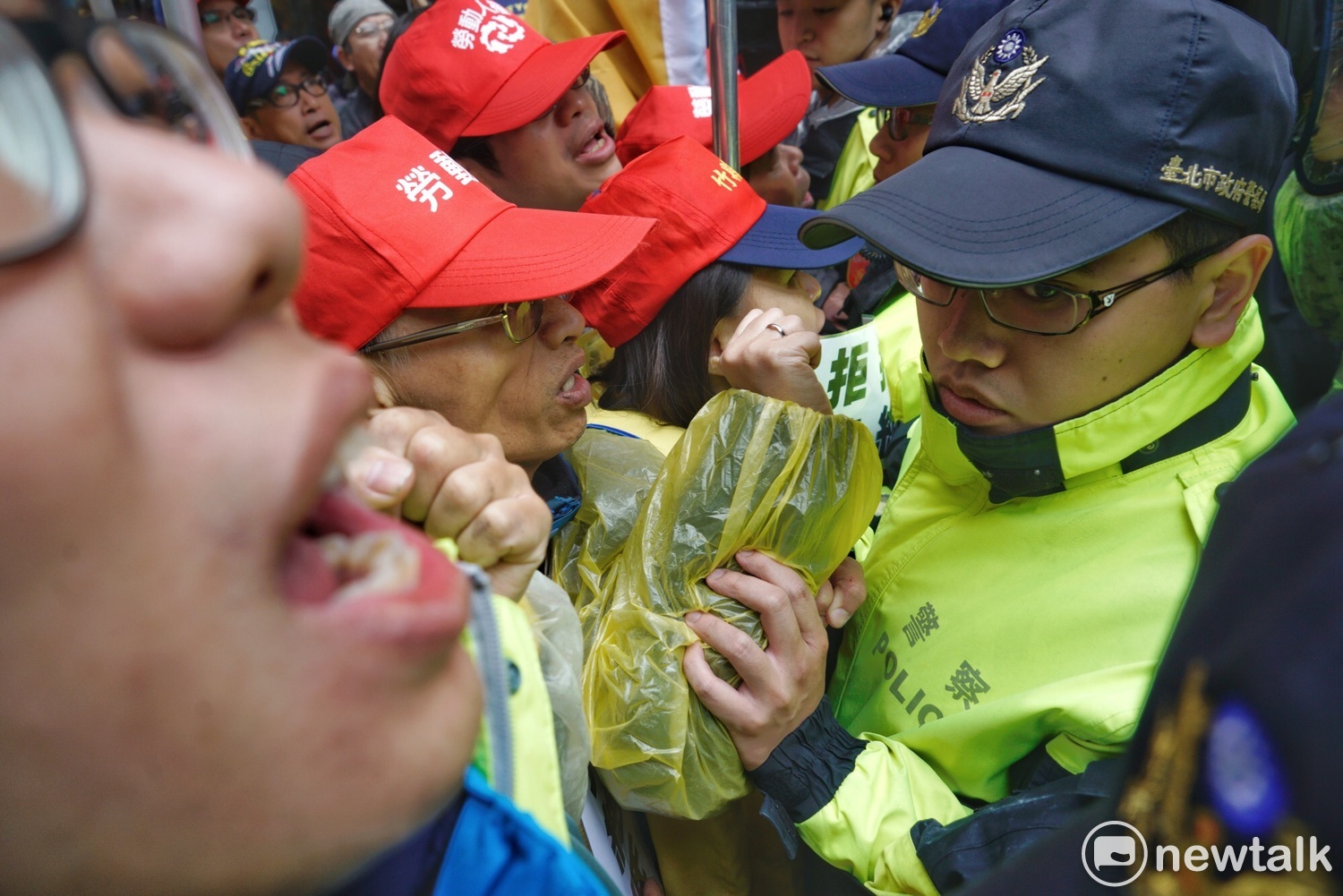 勞團高舉拳頭齊聲吶喊。 勞團高舉拳頭齊聲吶喊。