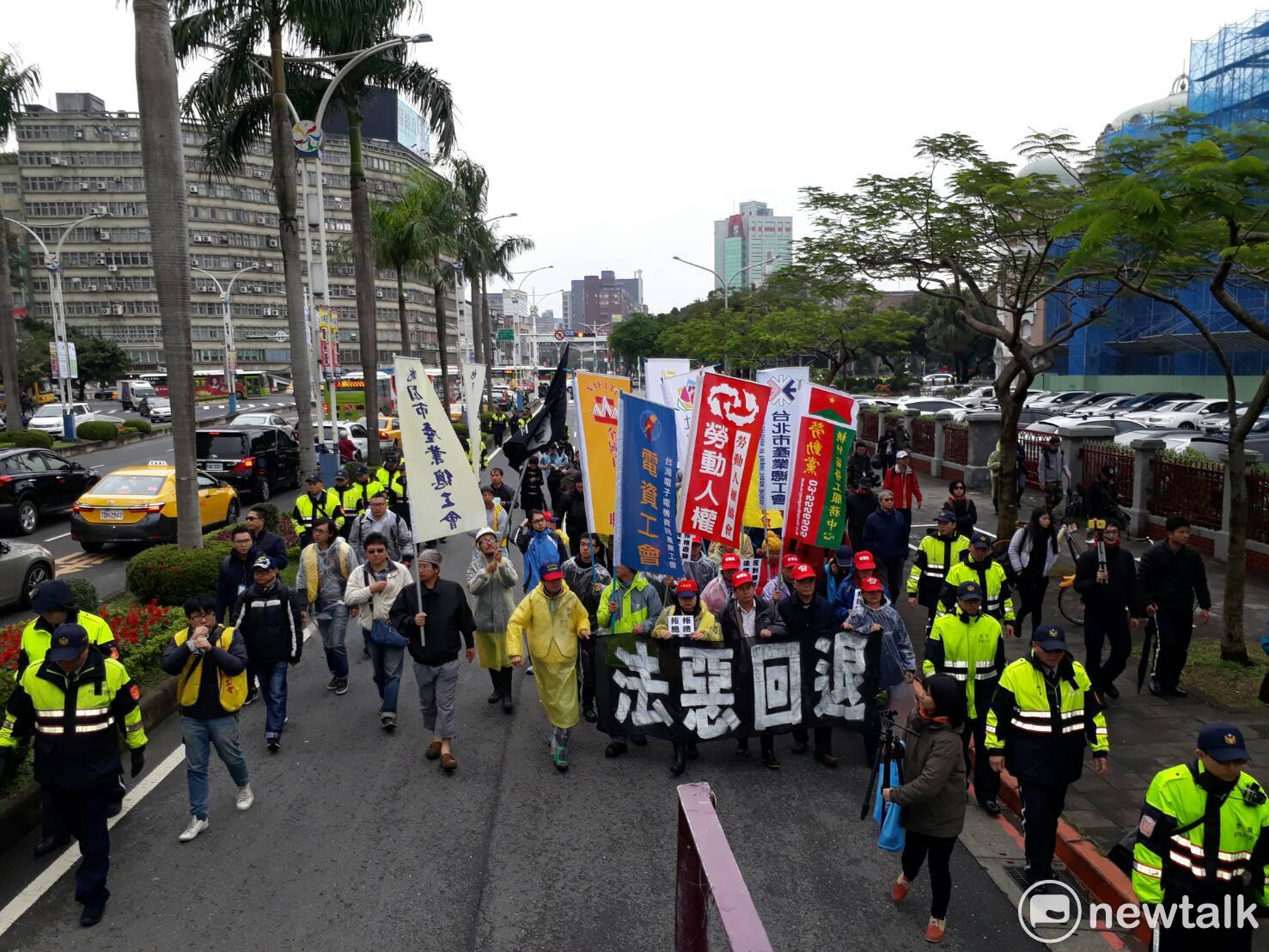 勞團高舉拳頭齊聲吶喊。 勞團高舉拳頭齊聲吶喊。