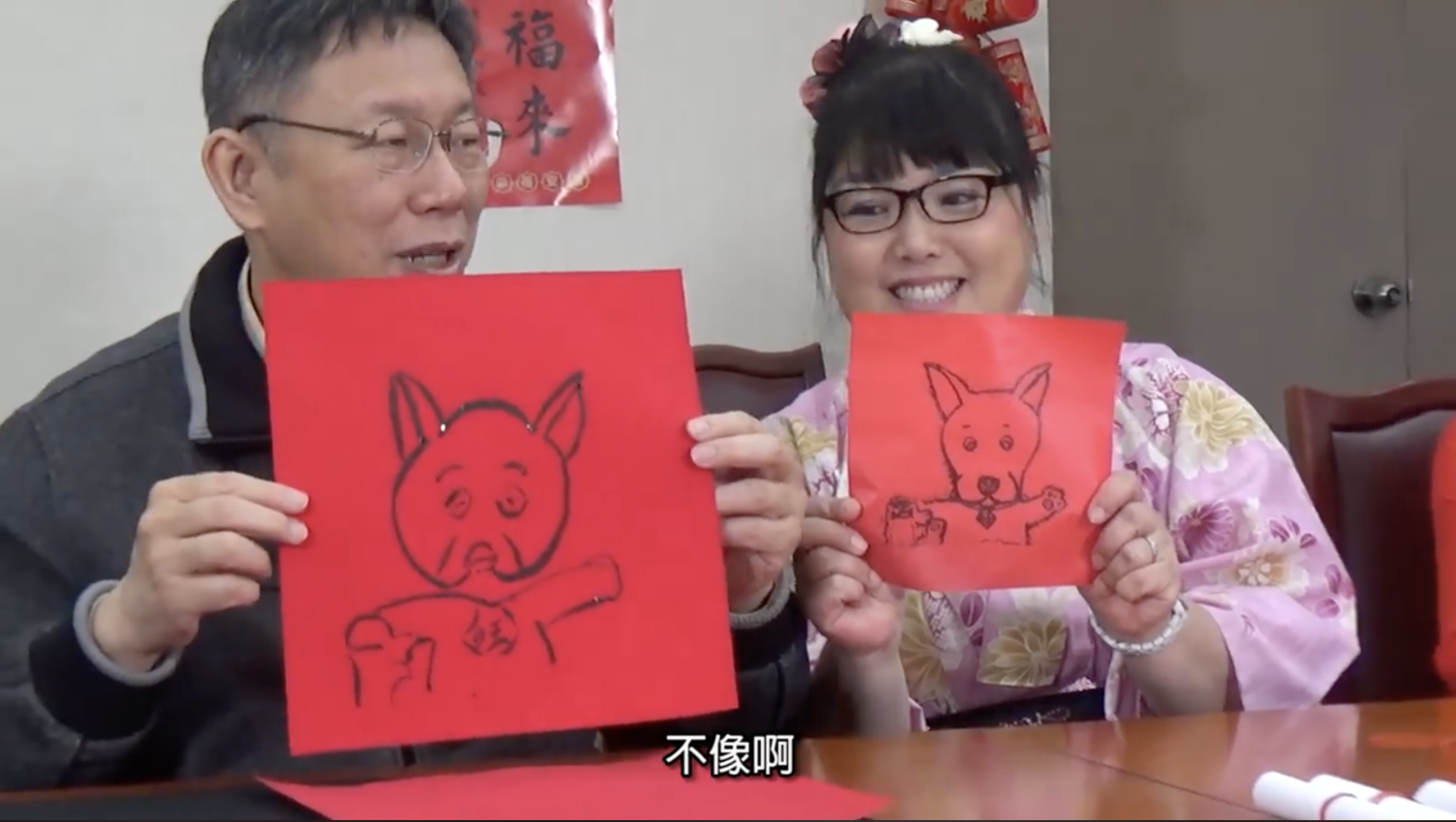 台北市長柯文哲嘗試在春聯上畫狗,自嘲畫得像豬。 圖:翻攝影片 台北市長柯文哲嘗試在春聯上畫狗,自嘲畫得像豬。 圖:翻攝影片