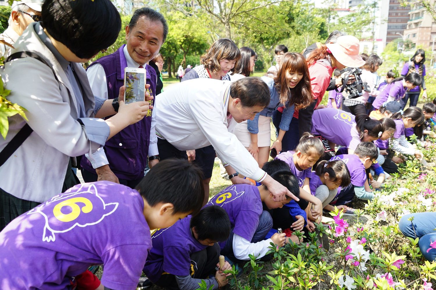 台北市副市長陳景峻今天和龍安國小學生一同親手種杜鵑花,「以花代樹」,小朋友都感到新鮮有趣 圖:台北市政府/提供 台北市副市長陳景峻今天和龍安國小學生一同親手種杜鵑花,「以花代樹」,小朋友都感到新鮮有趣 圖:台北市政府/提供