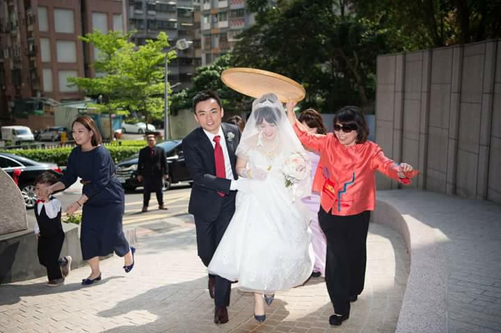 黃敏惠當起媒人婆,手持米篩為新娘遮陽,有趨吉避凶之意。 圖:婚禮攝影師洪年宏/提供 黃敏惠當起媒人婆,手持米篩為新娘遮陽,有趨吉避凶之意。 圖:婚禮攝影師洪年宏/提供