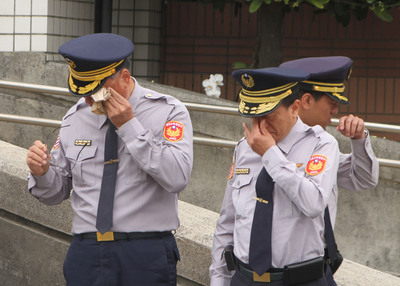 國道公路警察局第四公路警察大隊兩名殉職員警25日移靈,車隊繞行至兩人所屬的新市分隊,逾百名員警淚眼送行,儀式結束後頻頻拭淚。 圖:中央社 國道公路警察局第四公路警察大隊兩名殉職員警25日移靈,車隊繞行至兩人所屬的新市分隊,逾百名員警淚眼送行,儀式結束後頻頻拭淚。 圖:中央社
