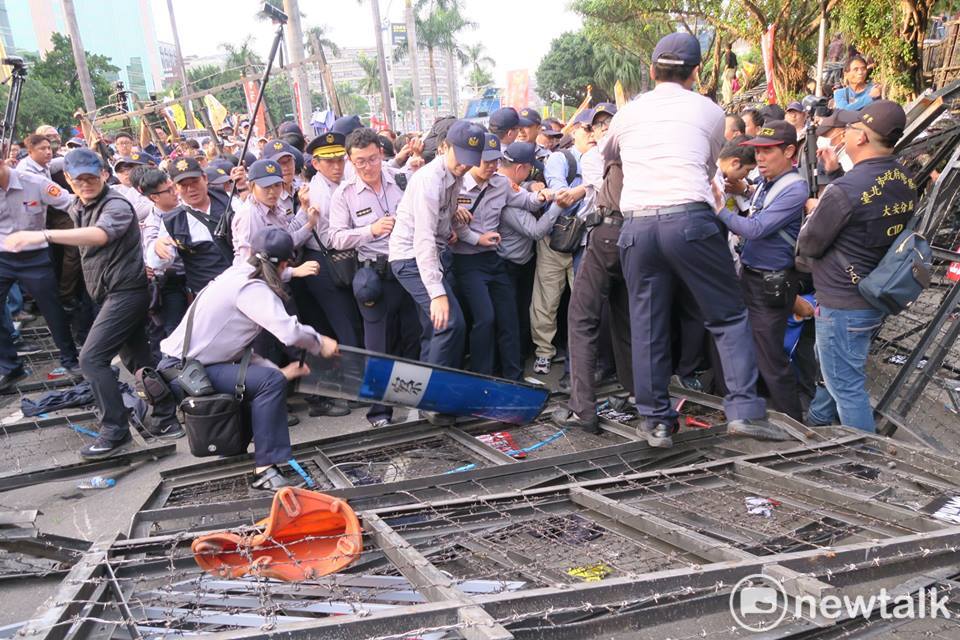 一陣推擠結果,女警趕緊拿盾牌遮住拒馬,避免有人掉落被刺到。 圖:邱萬興/攝 一陣推擠結果,女警趕緊拿盾牌遮住拒馬,避免有人掉落被刺到。 圖:邱萬興/攝