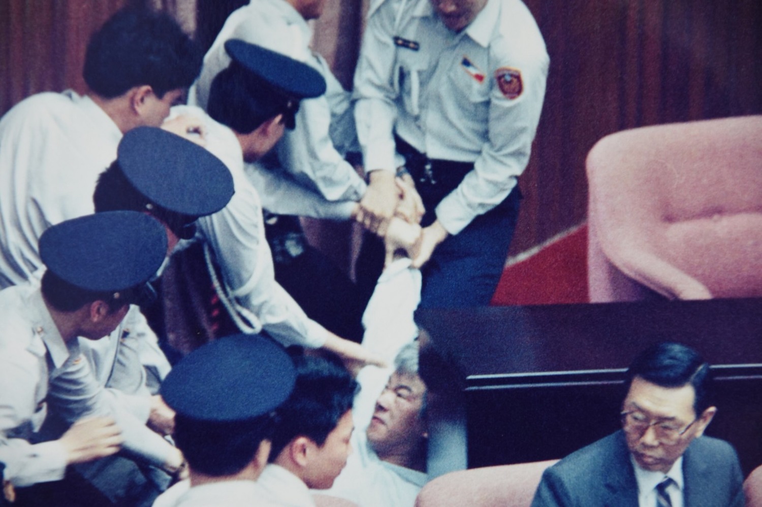 在立法院長梁肅戎的命令下,盧修一被立法院數十位駐警,像三明治一樣拉扯,毆打他。 在立法院長梁肅戎的命令下,盧修一被立法院數十位駐警,像三明治一樣拉扯,毆打他。