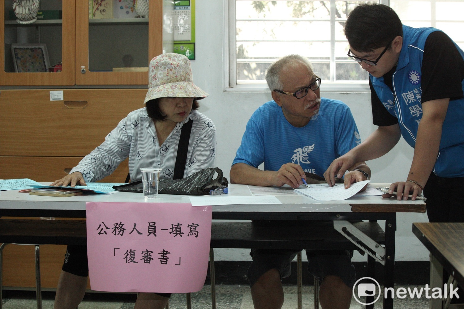 工作人員正為民眾說明如何填寫公務人員專用的復審申請書。 圖:林昀真/攝 工作人員正為民眾說明如何填寫公務人員專用的復審申請書。 圖:林昀真/攝