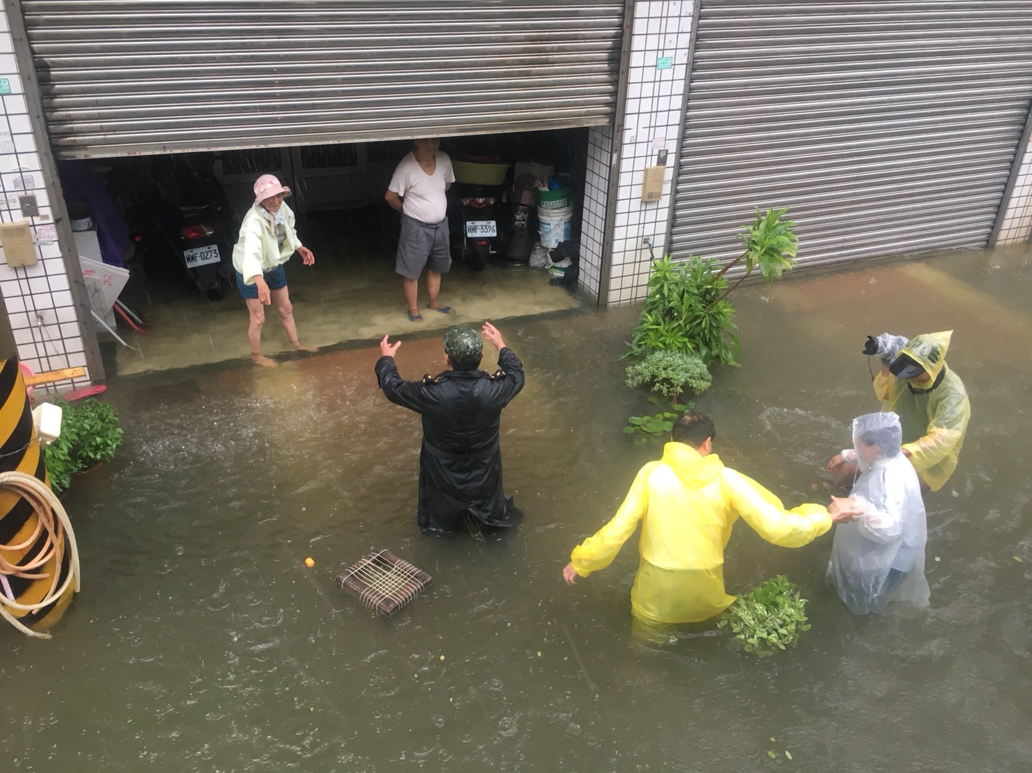 嘉義縣淹水嚴重,縣長張花冠(著白色雨衣者)關心受災民眾。 嘉義縣淹水嚴重,縣長張花冠(著白色雨衣者)關心受災民眾。