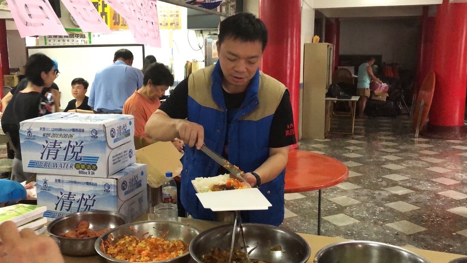 高思博前往北門區玉港里,與志工一起協助災民填寫災害補助申請表,並協助打飯供餐。 圖:黃博郎/攝影 高思博前往北門區玉港里,與志工一起協助災民填寫災害補助申請表,並協助打飯供餐。 圖:黃博郎/攝影