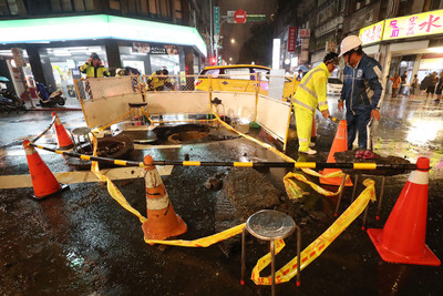 台北市8日降下大雨,造成西門町人孔蓋暴衝,水柱一 度衝到數層樓高,事發現場隨即被警方拉起封鎖線,台 北市衛生下水道工程處人員晚間也趕抵現場處理善後。 圖:中央社 台北市8日降下大雨,造成西門町人孔蓋暴衝,水柱一 度衝到數層樓高,事發現場隨即被警方拉起封鎖線,台 北市衛生下水道工程處人員晚間也趕抵現場處理善後。 圖:中央社