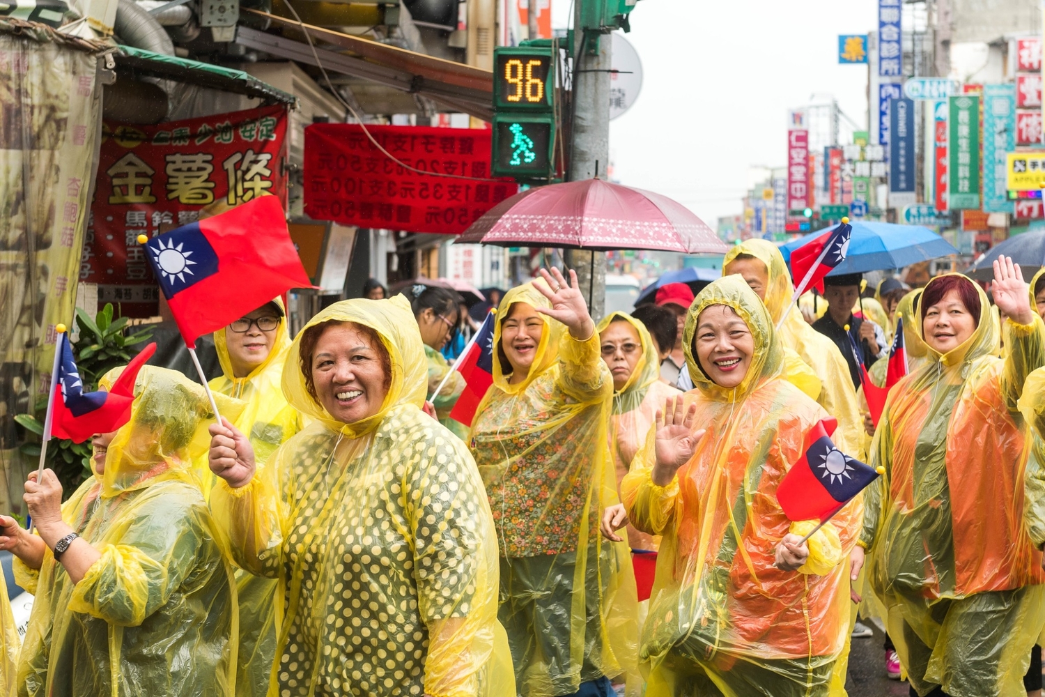 雖然天雨,還是有不少眷村媽媽們穿著雨衣踩街與社區熱情互動。 圖:桃園市政府/提供 雖然天雨,還是有不少眷村媽媽們穿著雨衣踩街與社區熱情互動。 圖:桃園市政府/提供