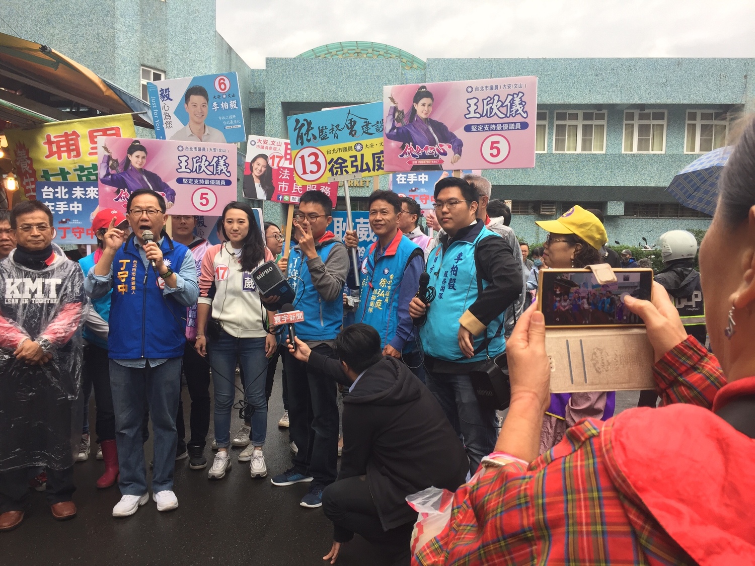 丁守中在木新市場大樓外進行簡短演講,甚至有熱情支持者也拿起相機拍攝紀錄下此時此刻。 圖:趙婉淳/攝 丁守中在木新市場大樓外進行簡短演講,甚至有熱情支持者也拿起相機拍攝紀錄下此時此刻。 圖:趙婉淳/攝
