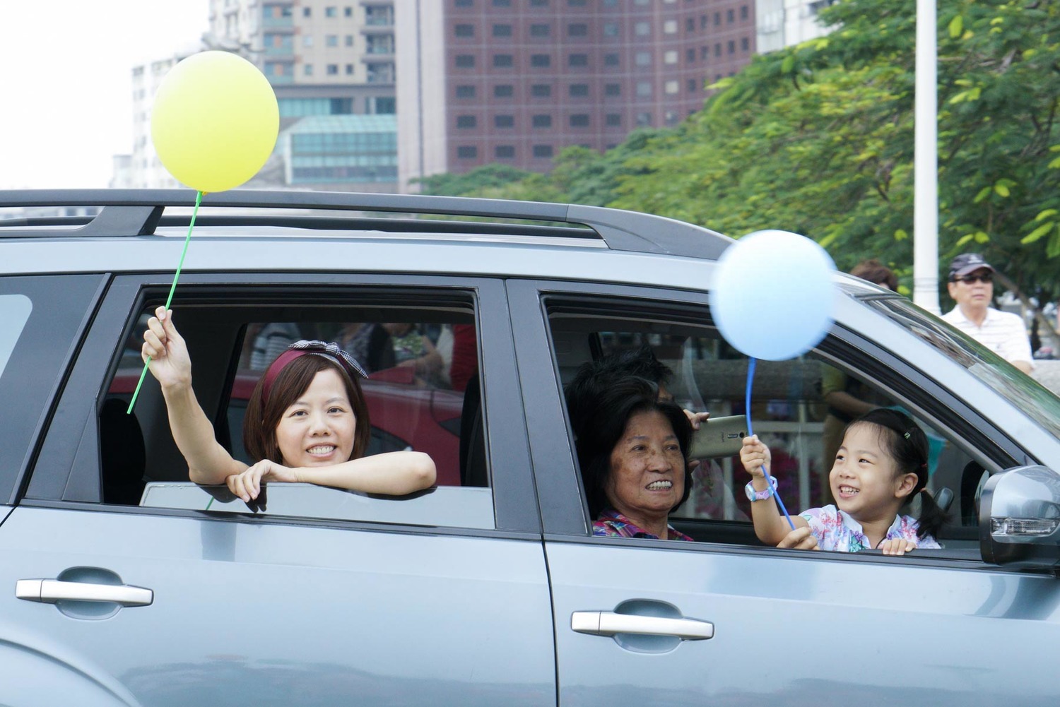 坐在車上的民眾拿著氣球和參加we care 遊行的民眾相呼應。 圖:張良一/攝 坐在車上的民眾拿著氣球和參加we care 遊行的民眾相呼應。 圖:張良一/攝