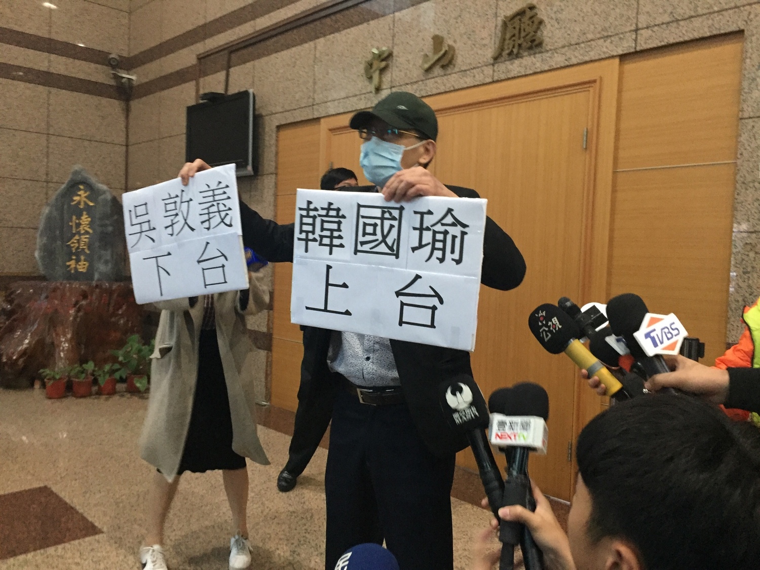 中常會召開前,有民眾手持「吳敦義下台、韓國瑜上台」告示牌抗議。 圖:趙婉淳/攝 中常會召開前,有民眾手持「吳敦義下台、韓國瑜上台」告示牌抗議。 圖:趙婉淳/攝