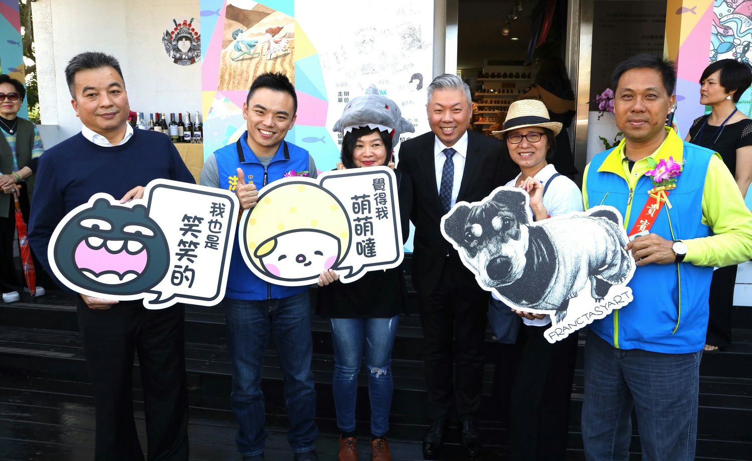 「秀233二館」開幕同時舉辦展覽,淡水區漁會總幹事吳永寬(左一)等人持可愛的手拿牌介紹。 圖:秀之藝術文化社提供 「秀233二館」開幕同時舉辦展覽,淡水區漁會總幹事吳永寬(左一)等人持可愛的手拿牌介紹。 圖:秀之藝術文化社提供
