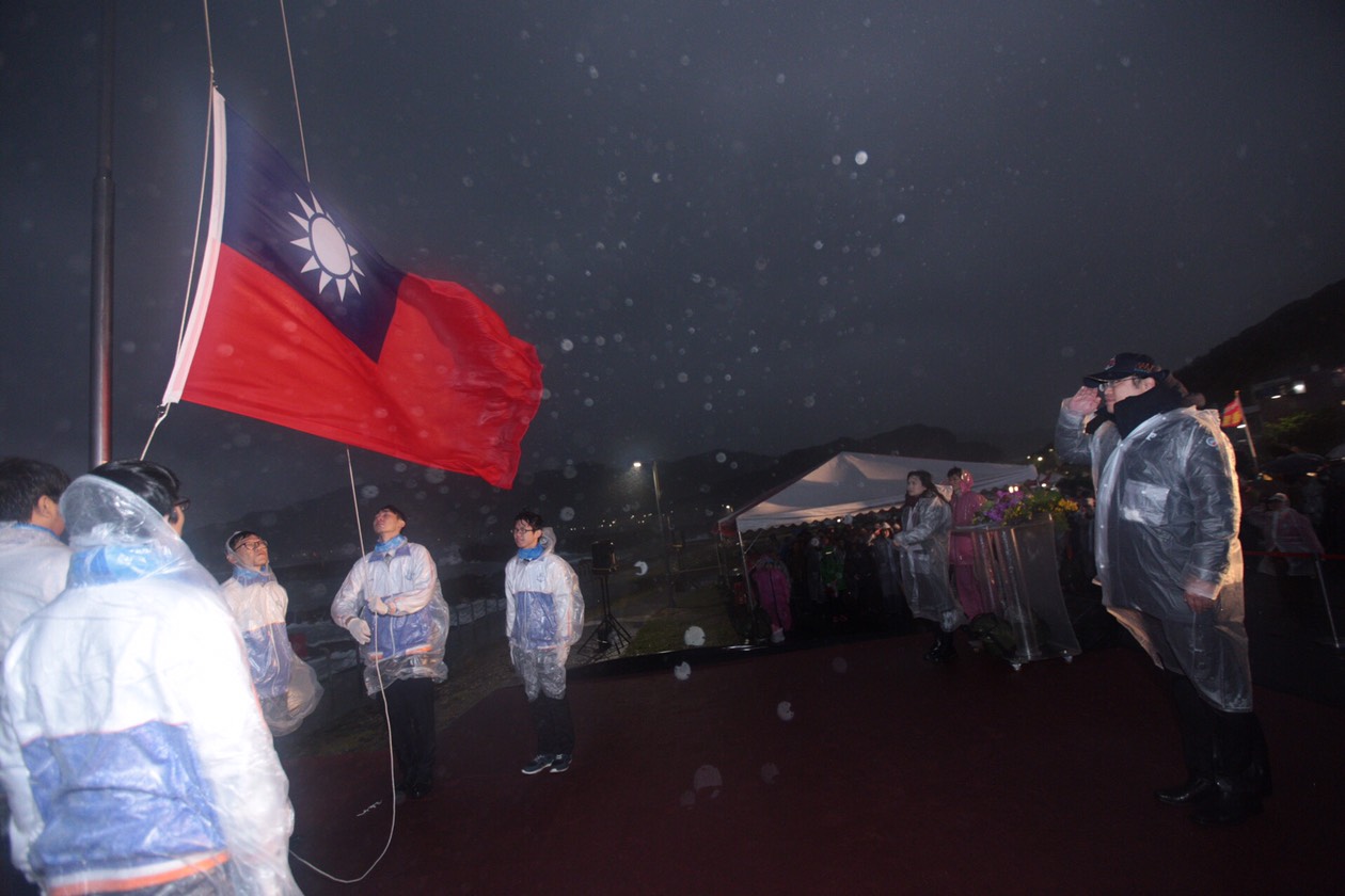 升旗典禮遇著惡劣天氣,暖暖高中的學生擔任升旗手。 圖:基隆市政府提供 升旗典禮遇著惡劣天氣,暖暖高中的學生擔任升旗手。 圖:基隆市政府提供