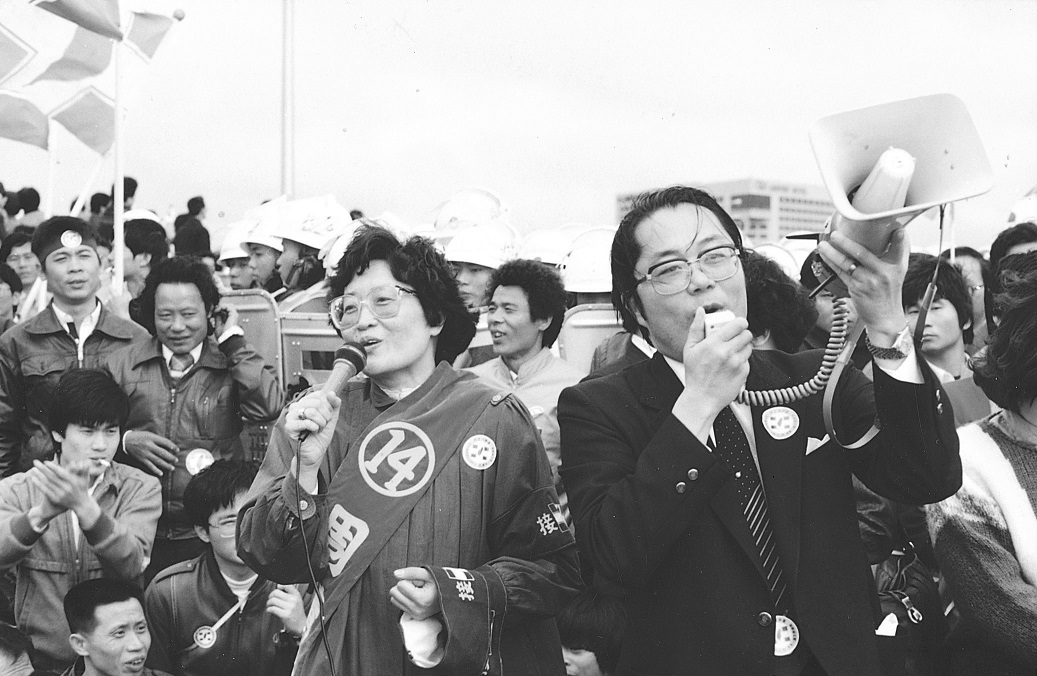 民進黨主席江鵬堅與周清玉國代在鎮暴隊伍前帶領民眾唱「黃昏的故鄉」,安撫被催淚瓦斯襲擊的現場民眾。 圖:邱萬興/攝 民進黨主席江鵬堅與周清玉國代在鎮暴隊伍前帶領民眾唱「黃昏的故鄉」,安撫被催淚瓦斯襲擊的現場民眾。 圖:邱萬興/攝