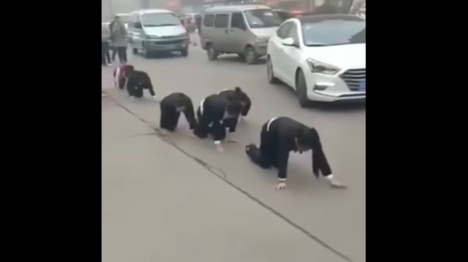 中國山東一間公司迫使女員工街頭集體跪地爬行,引發民眾與警方關注。 圖:翻攝自youtube 中國山東一間公司迫使女員工街頭集體跪地爬行,引發民眾與警方關注。 圖:翻攝自youtube