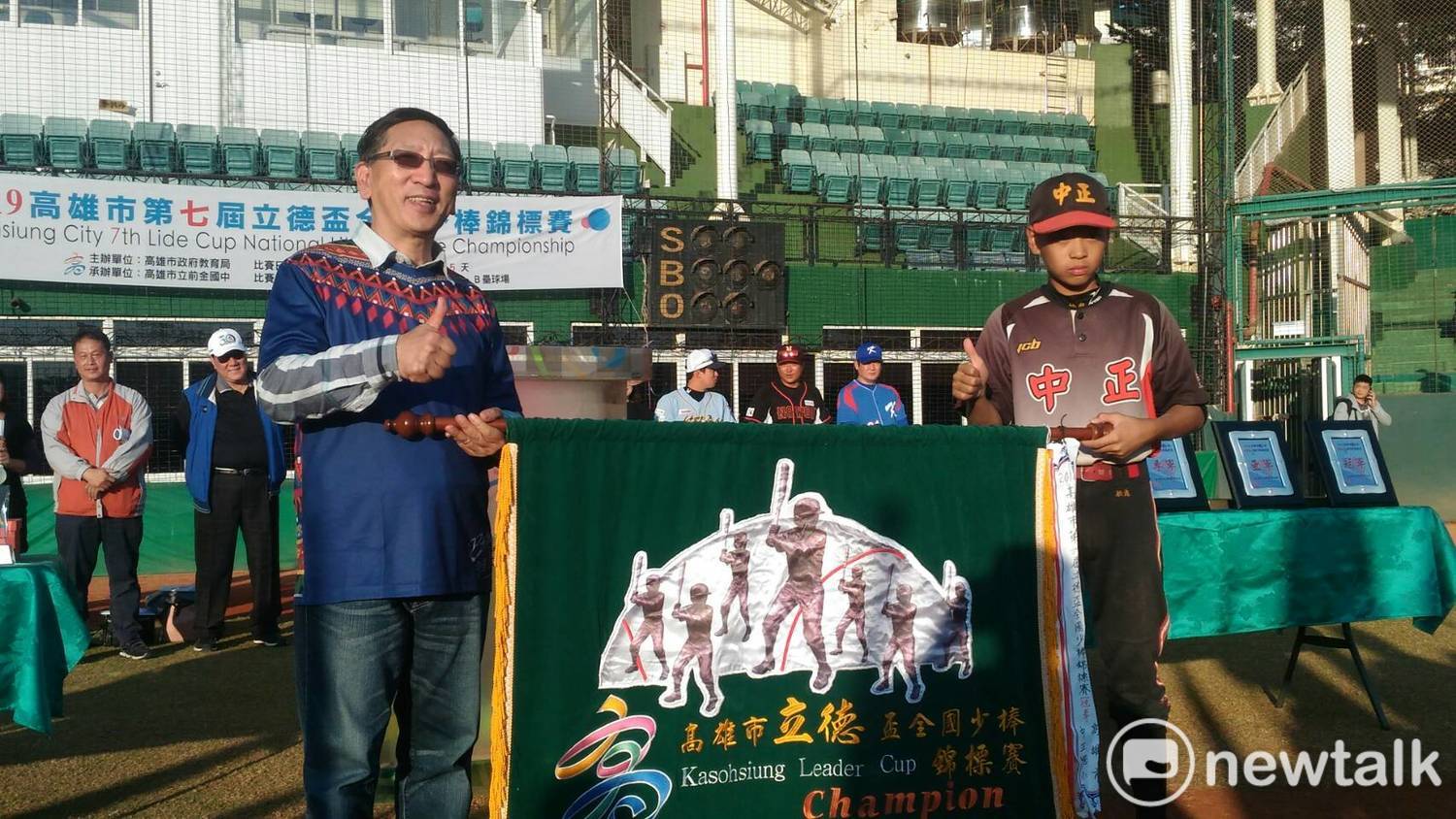 去年冠軍中正國小將冠軍旗交回給教肓局長吳榕峯(左)。 圖:孫家銘/攝 去年冠軍中正國小將冠軍旗交回給教肓局長吳榕峯(左)。 圖:孫家銘/攝
