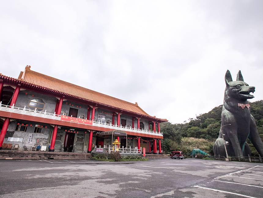 新十八王公廟位於半山腰,四周景緻優美,其中最大特色是,廟旁蹲坐一隻約有十層樓高的「黑龍義犬」塑像。 圖:取自新北市觀光旅遊網 新十八王公廟位於半山腰,四周景緻優美,其中最大特色是,廟旁蹲坐一隻約有十層樓高的「黑龍義犬」塑像。 圖:取自新北市觀光旅遊網