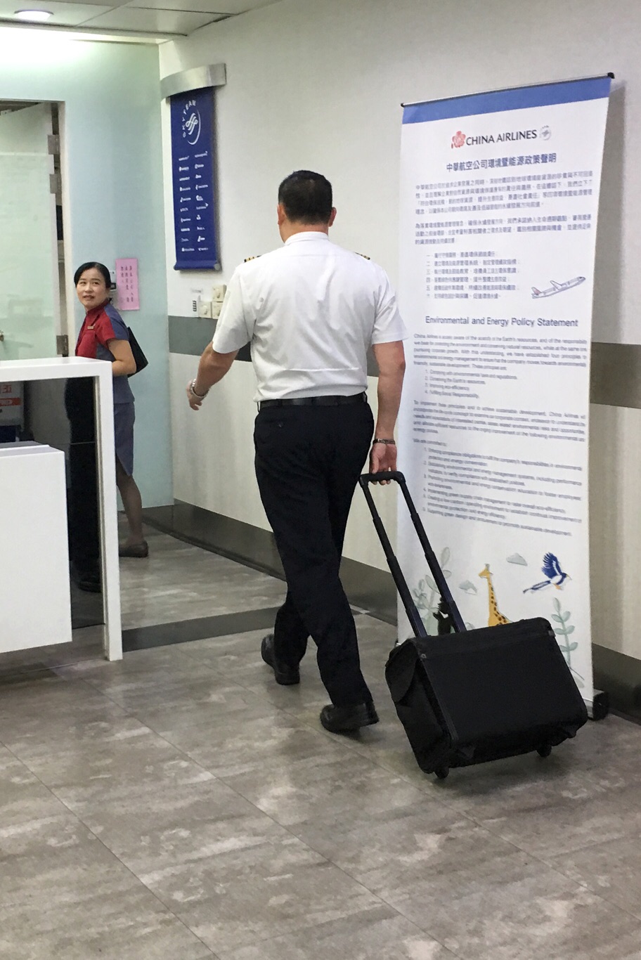 一位沒有參與罷工的華航機師拉著行李箱走進高雄小港國際機場出境大廳時,經過空蕩蕩的華航報到櫃檯,準備執勤。 圖:張良一攝 一位沒有參與罷工的華航機師拉著行李箱走進高雄小港國際機場出境大廳時,經過空蕩蕩的華航報到櫃檯,準備執勤。 圖:張良一攝