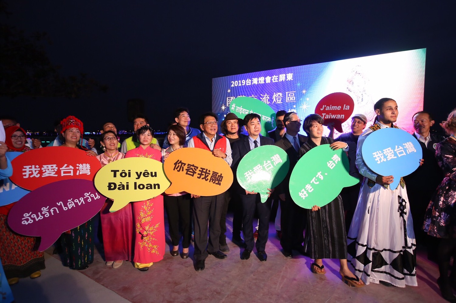 縣長潘孟安(紅背心)、內政部次長陳宗彥(打領帶)與現場來自各國的新住民姐妹齊喊:「我在台灣,我很好!」 圖:屏東縣政府提供 縣長潘孟安(紅背心)、內政部次長陳宗彥(打領帶)與現場來自各國的新住民姐妹齊喊:「我在台灣,我很好!」 圖:屏東縣政府提供