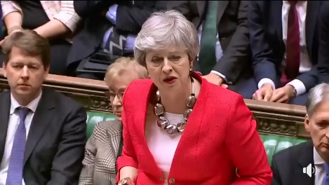 英國首相梅伊(前)12日在國會表決前,「燒聲」說明脫歐協議,現場卻噓聲不斷。 圖:翻攝自英國首相臉書影片 英國首相梅伊(前)12日在國會表決前,「燒聲」說明脫歐協議,現場卻噓聲不斷。 圖:翻攝自英國首相臉書影片
