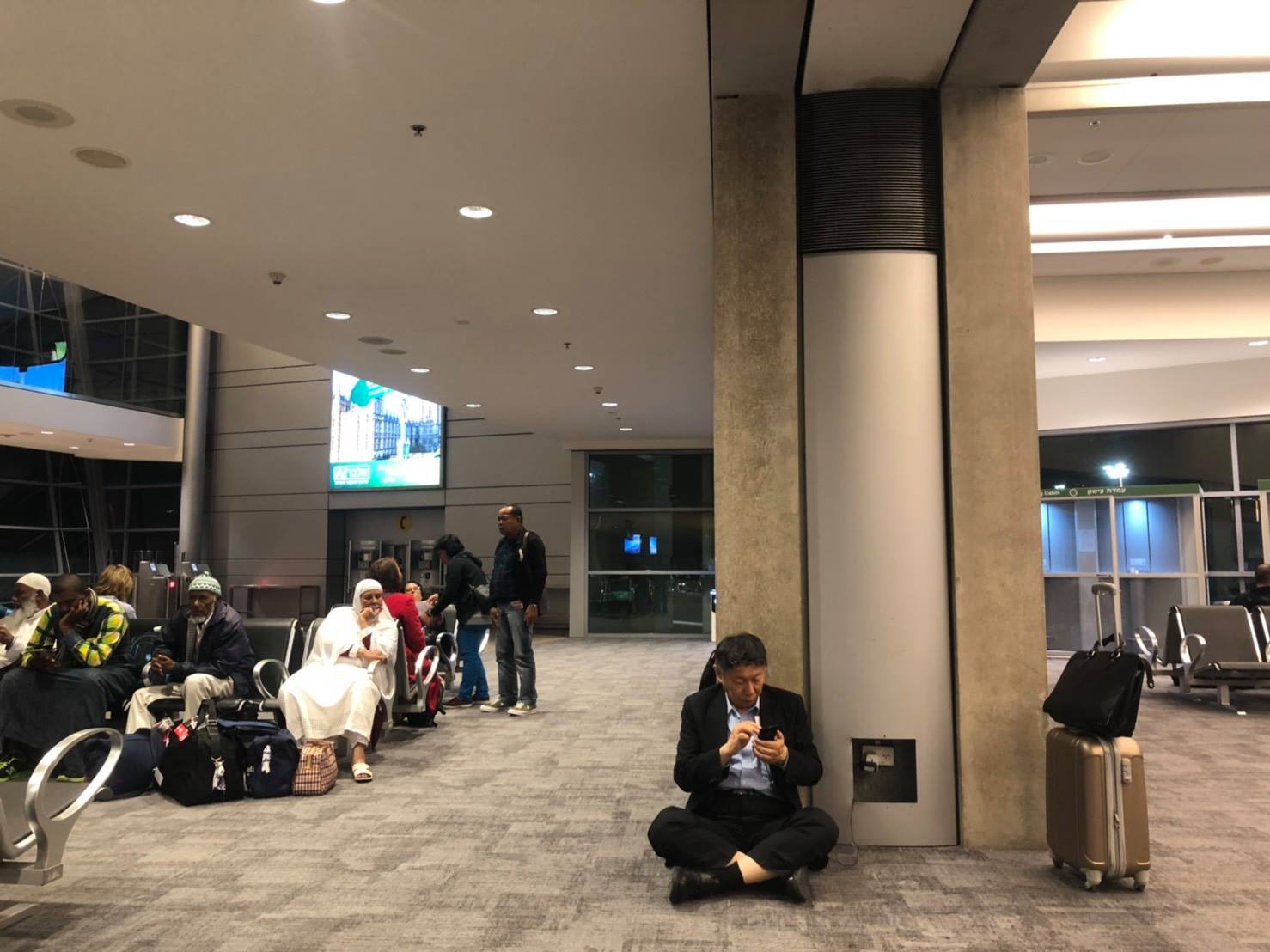 柯文哲上個月訪以色列返國時,在臉書PO出一張坐在機場充電的照片,遭王世堅酸是「假親民、假隨興」。 圖:翻攝自 柯文哲臉書