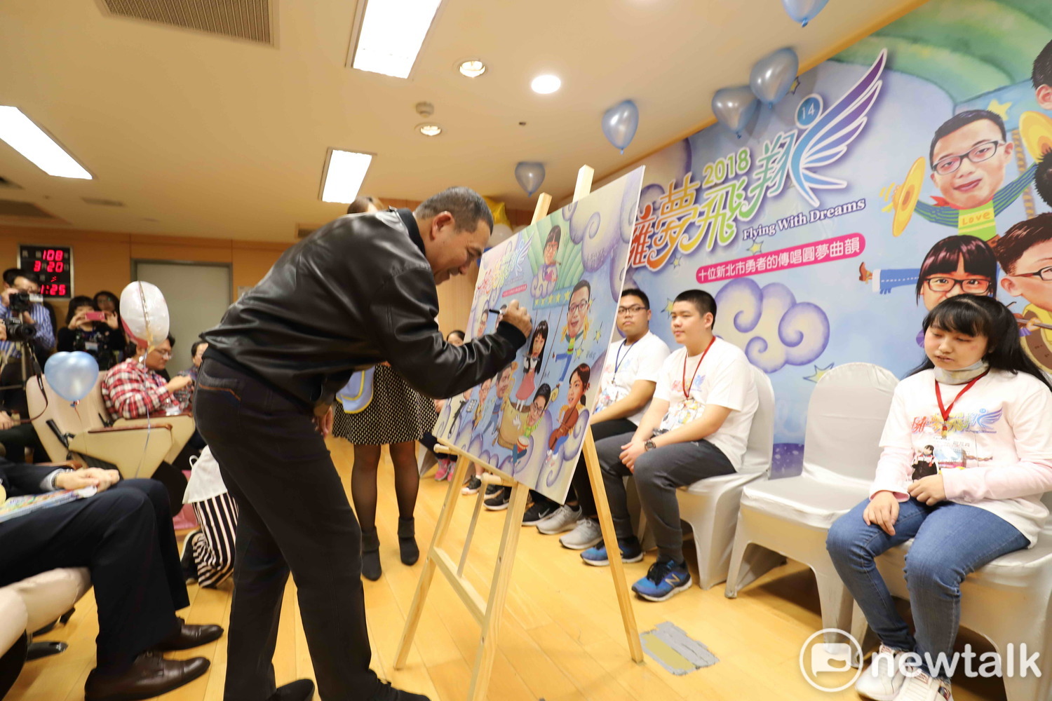 侯友宜在《擁夢飛翔14》新書發表會的擁夢拼圖上簽名,肯定10位生命勇者的奮鬥不懈。 圖:王峻昌/攝 侯友宜在《擁夢飛翔14》新書發表會的擁夢拼圖上簽名,肯定10位生命勇者的奮鬥不懈。 圖:王峻昌/攝