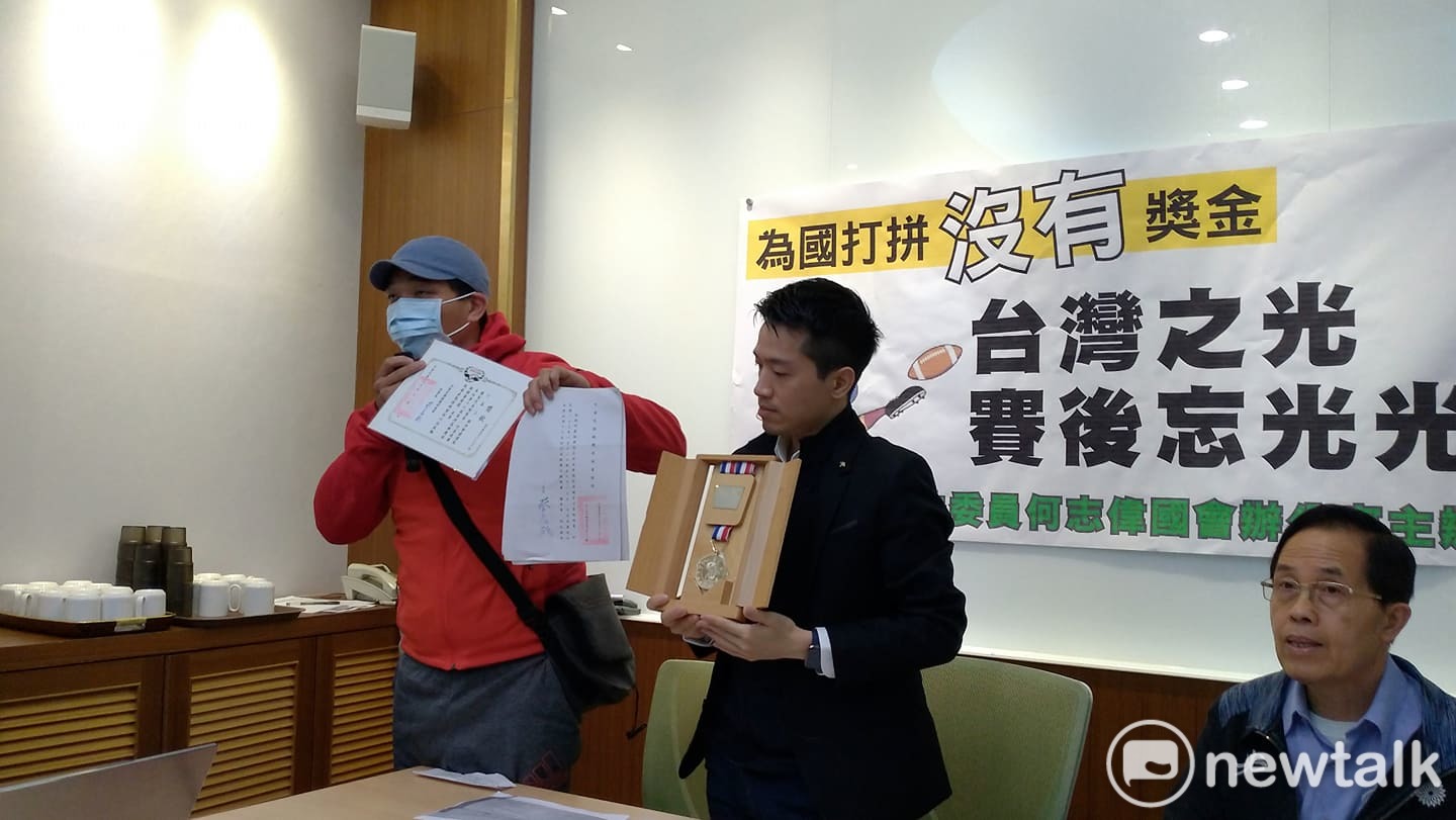 選手嚴先生秀出獎章陳情。 圖:陳佩君/攝 選手嚴先生秀出獎章陳情。 圖:陳佩君/攝
