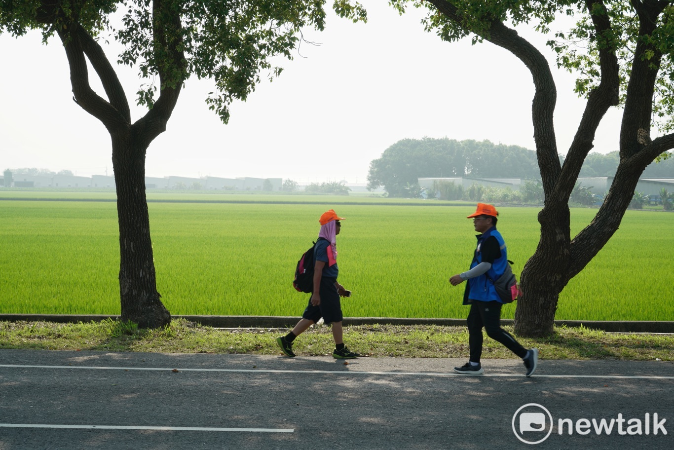 兩位白沙屯媽祖的信徒在北港鎮郊,朝著不同的方向前進。 圖:張良一/攝 兩位白沙屯媽祖的信徒在北港鎮郊,朝著不同的方向前進。 圖:張良一/攝
