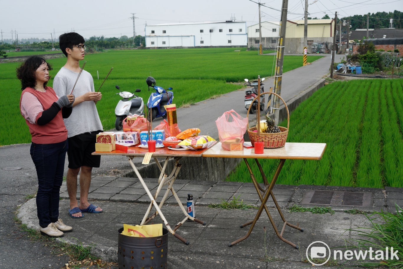 彰化溪州兩位民眾在路旁擺設供桌,向經過的白沙屯媽祖上香祈福。 圖:張良一/攝 彰化溪州兩位民眾在路旁擺設供桌,向經過的白沙屯媽祖上香祈福。 圖:張良一/攝
