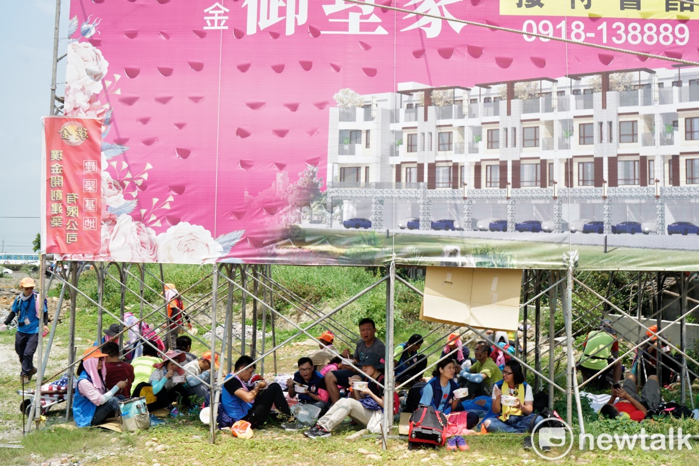 正中午天氣炎熱,而且太陽又大,許多信眾或蹲或坐,在廣告鷹架下方躲太陽。 圖:張良一/攝 正中午天氣炎熱,而且太陽又大,許多信眾或蹲或坐,在廣告鷹架下方躲太陽。 圖:張良一/攝