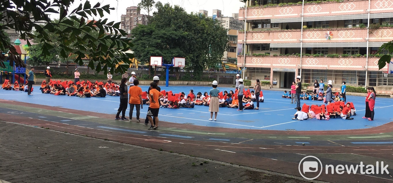 今天中午地震後,北市忠義國小小朋友戴上橘色的防災頭套,在操場防災。 圖:張良一/攝 今天中午地震後,北市忠義國小小朋友戴上橘色的防災頭套,在操場防災。 圖:張良一/攝
