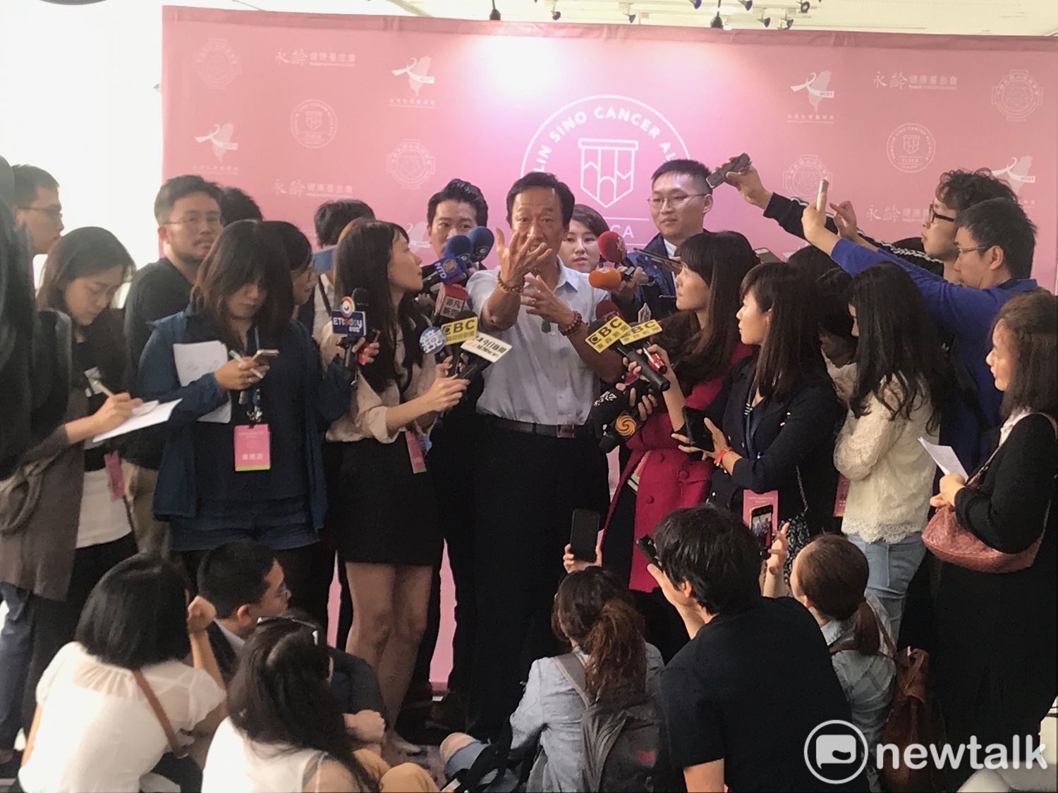 鴻海董事長郭台銘生動還原當天自己幫攝影記者綁鞋帶的情形。 圖:周煊惠 /攝 鴻海董事長郭台銘生動還原當天自己幫攝影記者綁鞋帶的情形。 圖:周煊惠 /攝