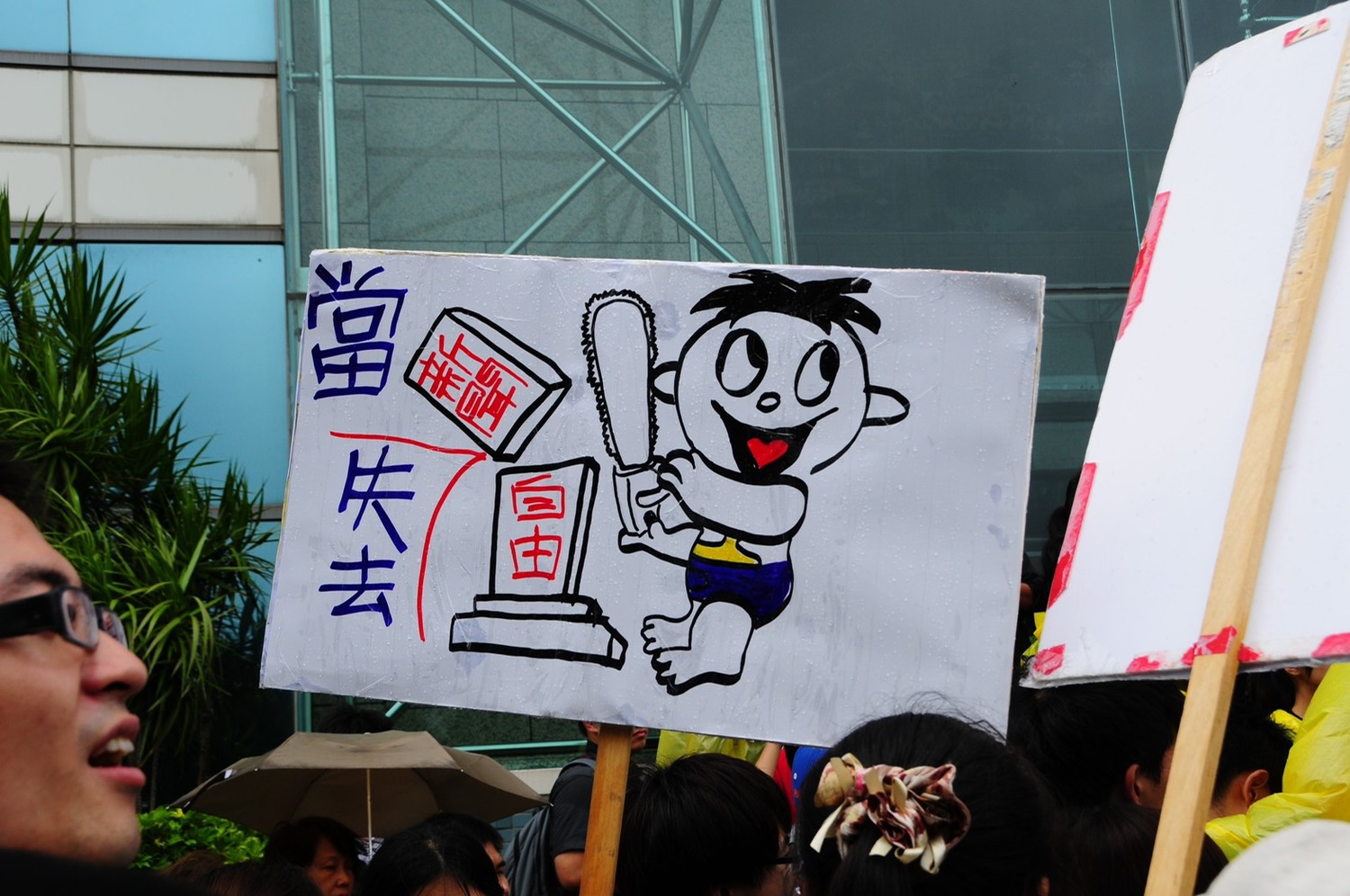 遊行中有民眾高舉「新聞自由」遭剝奪的示牌,強調旺中集團併購案的後患。 遊行中有民眾高舉「新聞自由」遭剝奪的示牌,強調旺中集團併購案的後患。