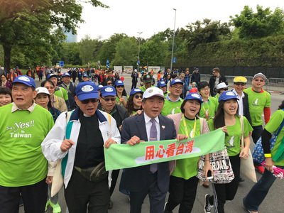 衞福部長陳時中(前左3)19日參與世界衛生組織舉辦的一場健走活動,並手持「用心看台灣」布條。 圖:中央社 衞福部長陳時中(前左3)19日參與世界衛生組織舉辦的一場健走活動,並手持「用心看台灣」布條。 圖:中央社