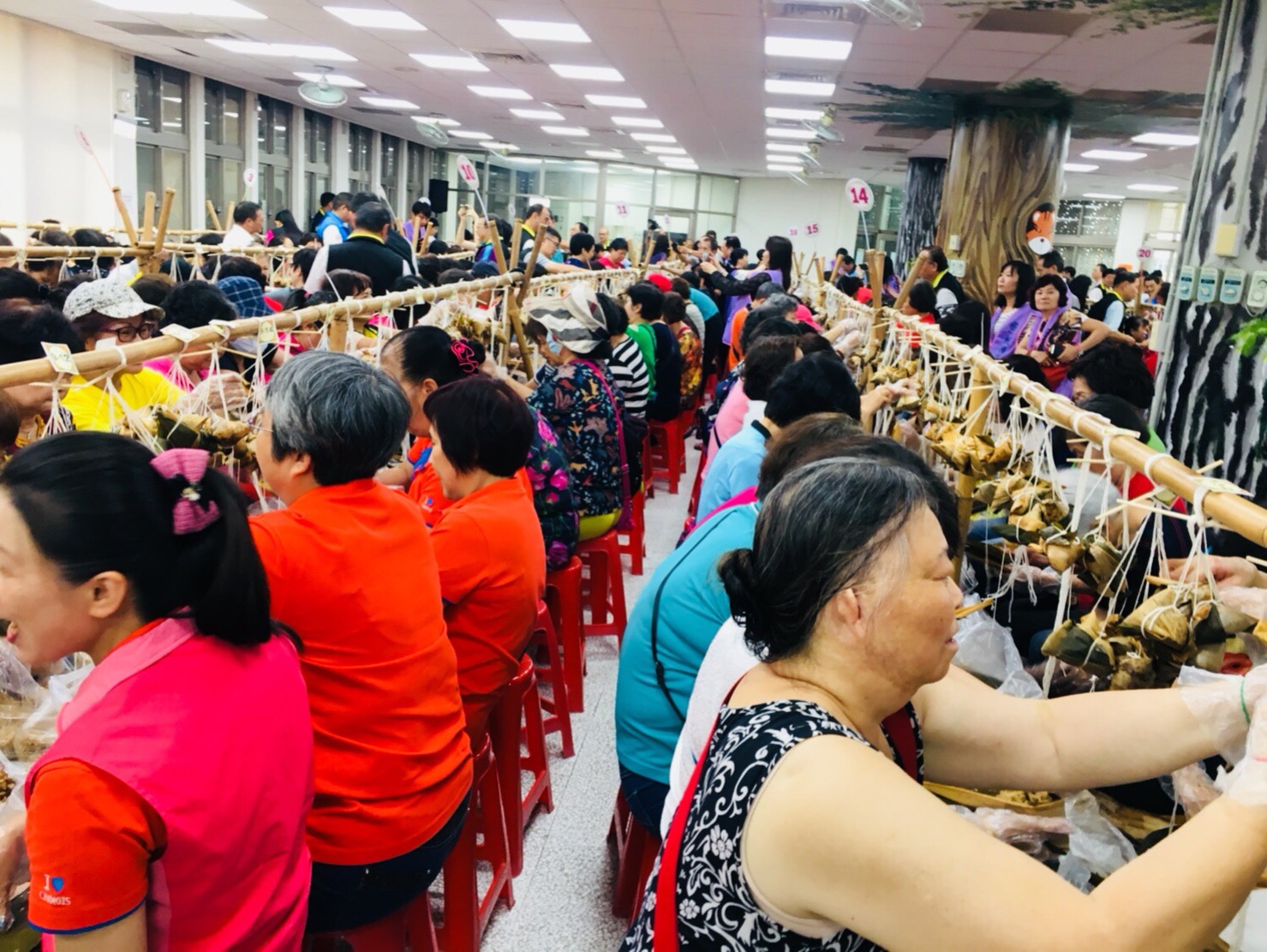 「2019新北慶端午-益起包粽送愛心」公益活動,有板橋區里長、志工與里民等500人參加,熱鬧又熱情。 圖:板橋區公所提供 「2019新北慶端午-益起包粽送愛心」公益活動,有板橋區里長、志工與里民等500人參加,熱鬧又熱情。 圖:板橋區公所提供
