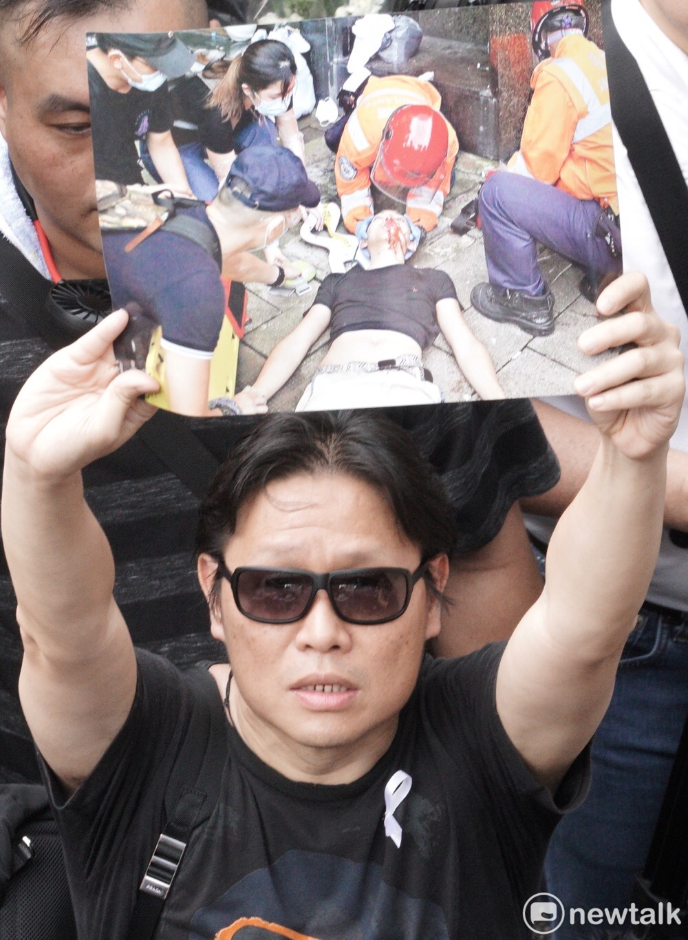 港民拿出示威者遭到香港警方槍擊照片,表達出「追究開槍責任」的訴求。 圖:張良一 / 攝 港民拿出示威者遭到香港警方槍擊照片,表達出「追究開槍責任」的訴求。 圖:張良一 / 攝