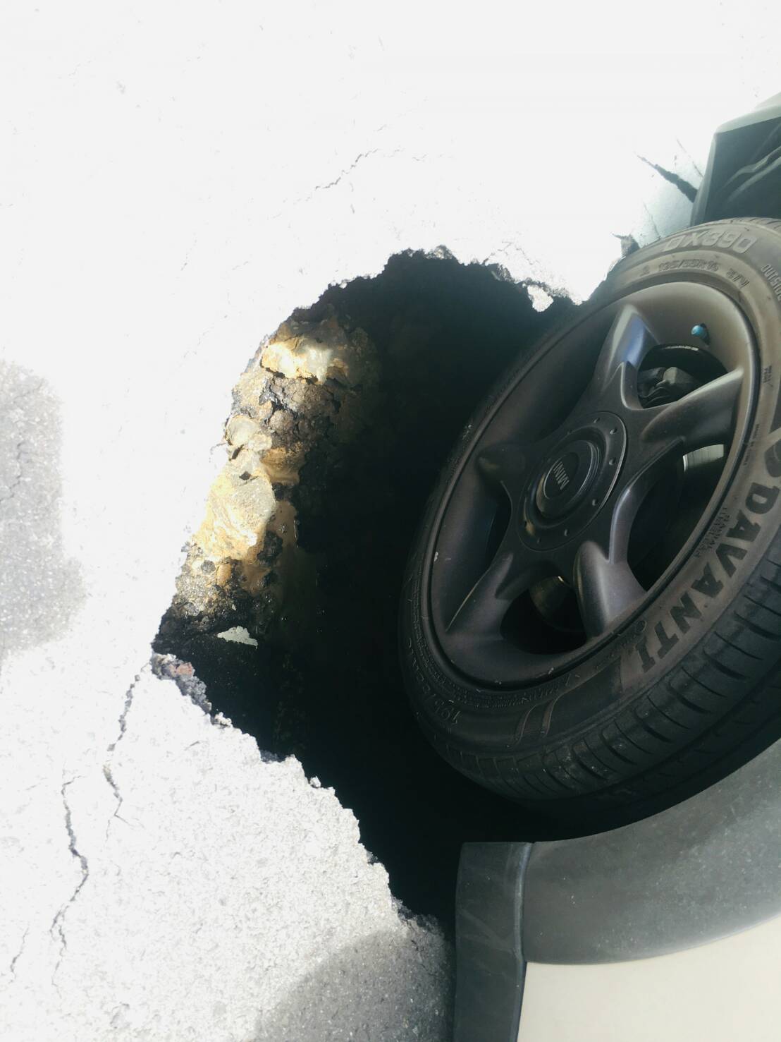 高雄市路面破洞,小轎車前輪陷入。 圖 : 翻攝自網路 高雄市路面破洞,小轎車前輪陷入。 圖 : 翻攝自網路