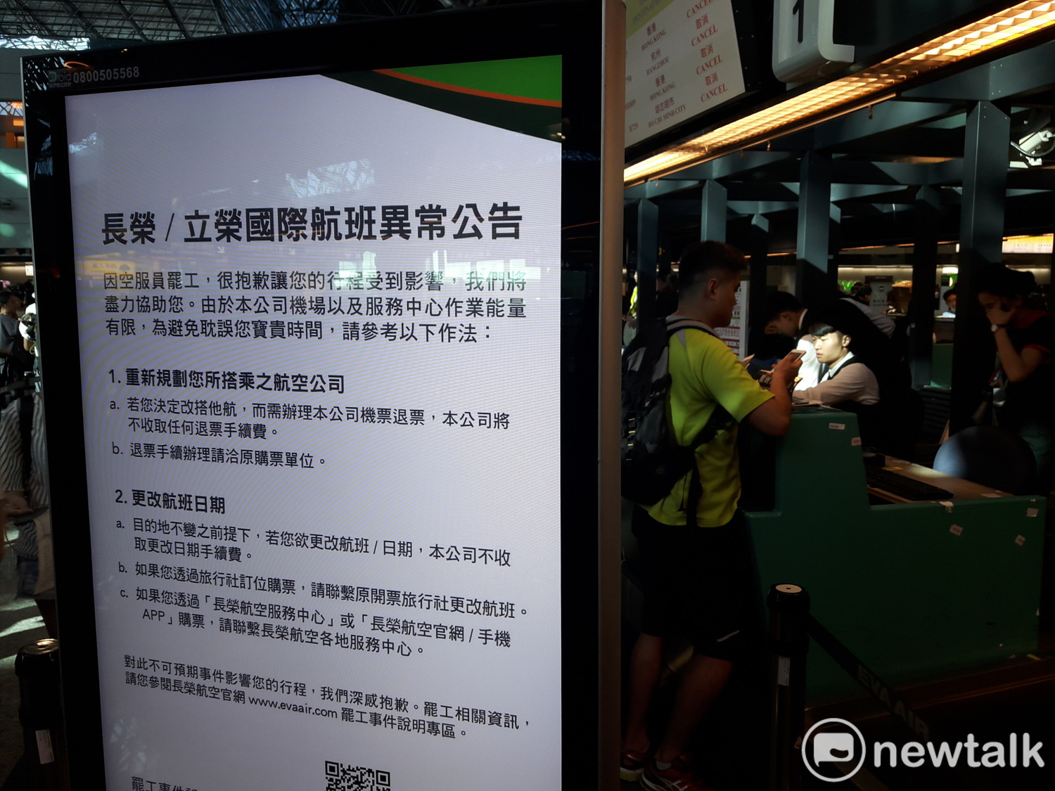 長榮航空櫃台人員正在向旅客說明航班取消資訊。 圖:林昀真/攝 長榮航空櫃台人員正在向旅客說明航班取消資訊。 圖:林昀真/攝