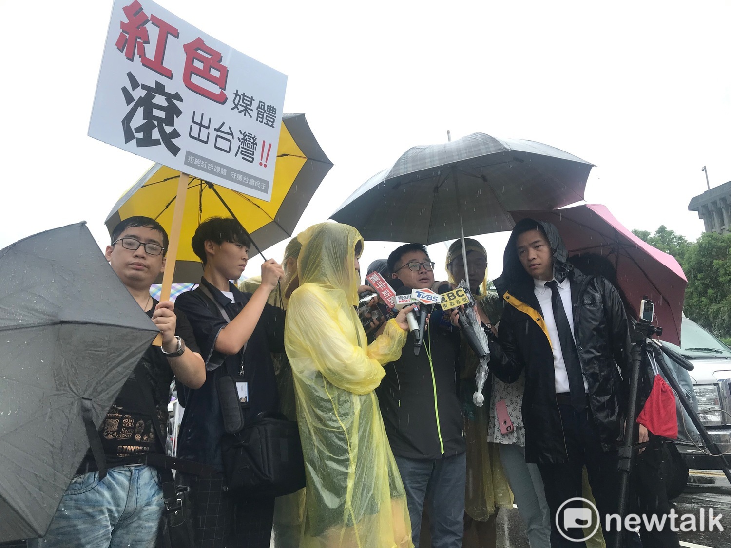 羅文嘉受訪時,有民眾高舉「紅色媒體、滾出台灣」標語。 圖:周煊惠 /攝 羅文嘉受訪時,有民眾高舉「紅色媒體、滾出台灣」標語。 圖:周煊惠 /攝