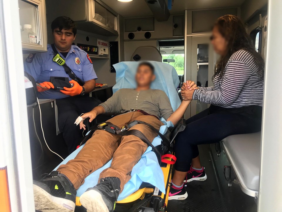 在美墨邊界的里奧格蘭德河獲救少年(中)撿回一命,被送上救護車,親人緊握他的手。 圖:翻攝自美國白宮臉書 在美墨邊界的里奧格蘭德河獲救少年(中)撿回一命,被送上救護車,親人緊握他的手。 圖:翻攝自美國白宮臉書