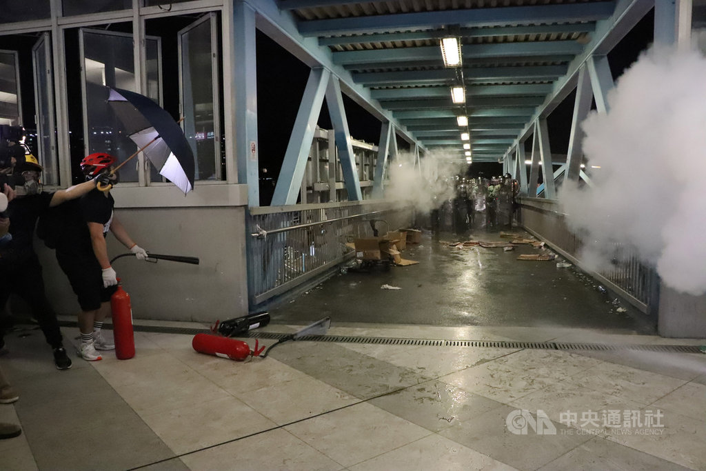 港警速龍小隊晚間近10時,直接攻上西鐵元朗站內,與站內示威者爆發約短暫衝突,在逮捕數名示威者後撤離。圖為示威者在站內與防暴警察攻防對峙。 圖:中央社提供。 港警速龍小隊晚間近10時,直接攻上西鐵元朗站內,與站內示威者爆發約短暫衝突,在逮捕數名示威者後撤離。圖為示威者在站內與防暴警察攻防對峙。 圖:中央社提供。