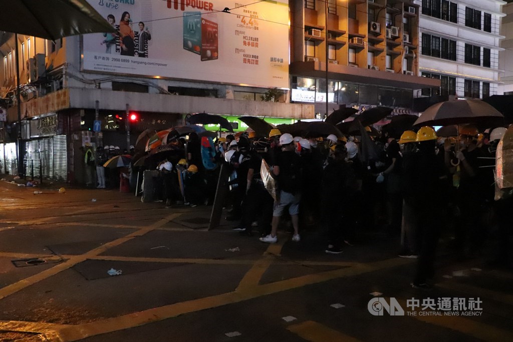 香港中環遮打花園追究警方用槍集會,演變為西環包圍中聯辦;港警晚間7時起清場,沿途狂射催淚彈意圖逼退示威者,有記者、示威者頭破血流,多人遭逮捕。圖為警方與示威者在上環一帶對峙。 圖:中央社提供。 香港中環遮打花園追究警方用槍集會,演變為西環包圍中聯辦;港警晚間7時起清場,沿途狂射催淚彈意圖逼退示威者,有記者、示威者頭破血流,多人遭逮捕。圖為警方與示威者在上環一帶對峙。 圖:中央社提供。