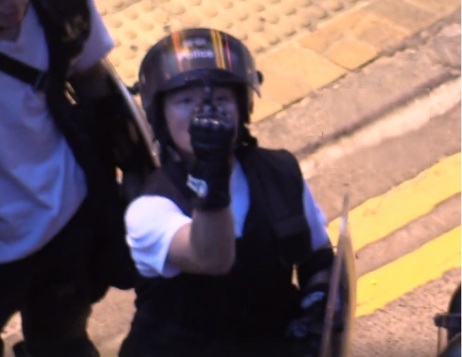 便衣港警對中大學生記者比中指挑釁,且不斷以強光照射阻撓拍攝。 圖:翻攝自中大學生報臉書 便衣港警對中大學生記者比中指挑釁,且不斷以強光照射阻撓拍攝。 圖:翻攝自中大學生報臉書